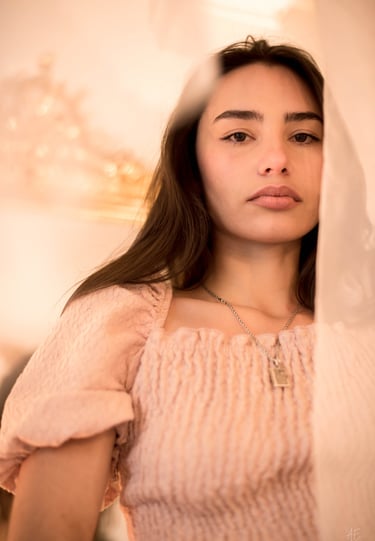 une jeune femme brune avec les cheveux longs et un collier