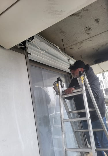 homme sur echelle avec volet roulant