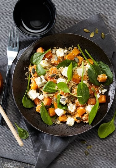 a bowl of food with a wooden spoon and a wooden spoon next to it