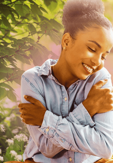 Mulher se abraça feliz em autocompaixão