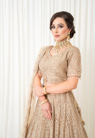 elegant asian bride dressed in traditional gold outfit with soft glamour makeup in a fashion pose 