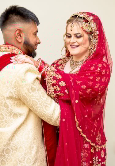 candid photo of bride and asian groom, bride's hand on groom shoulder, both laughing and having a good time
