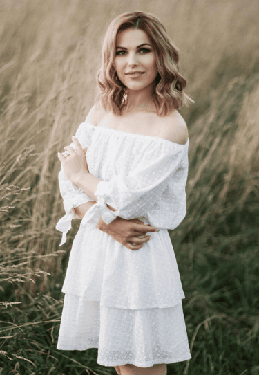 a woman in a white dress standing in a field