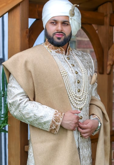 Portrait of Regal groom in traditional gold outfit, light and airy photo  