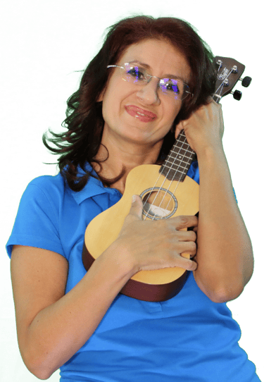 a woman in glasses and a blue shirt holding a ukulele
