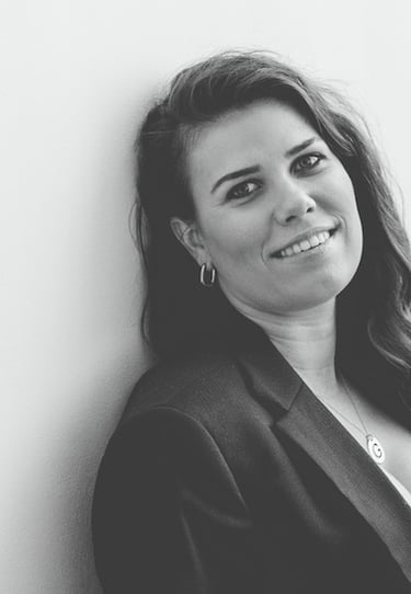 Vrouw in professioneel pak met lang krullend haar en sieraden om