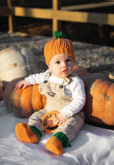 Super cute photo of baby boy in a pumpkin patch, dressed as a pumpkin.