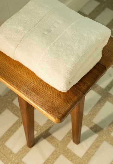 Tabouret en bois sur sol en marbre Carlo Scarpa dans une salle de bain sur mesure à Paris