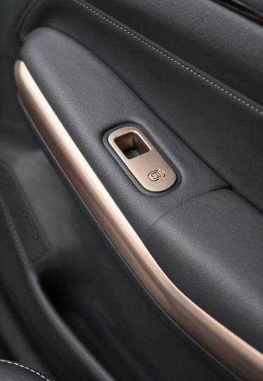 Interior detail of a luxury vehicle, charcoal gray leather stitching and muted champagne gold metal accents, North American / US automotive design.