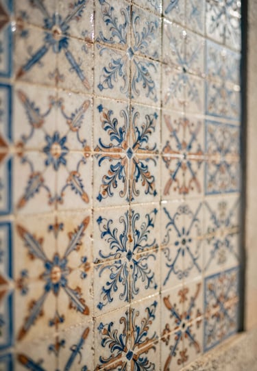 Detail of local Portuguese tiles on a sunny wall, intricate patterns in sand and terracotta, soft cinematic blur.