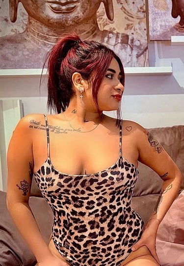 Chica colombiana en body animal print sobre el sofá mostrando su escote