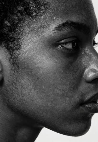 Artistic profile shot focusing on skin texture and geometric form. High-contrast photography in shades of black, gray, and white. International / Professional.