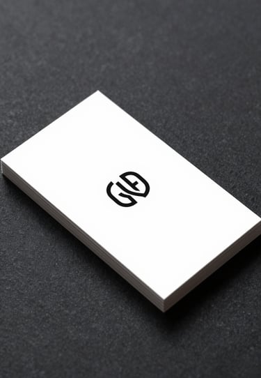 A minimalist white business card resting on a dark, textured surface (#4A5763). The card features a sophisticated black logo with refined lines.