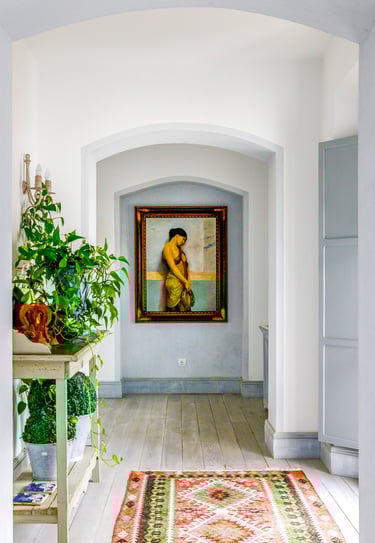 Hallway with flowers, paintings and rugs at Finca Santa Katerina