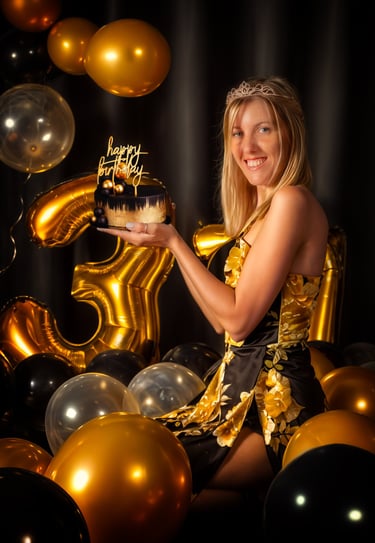 a woman holding a cake with a golden birthday cake