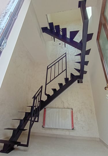 Arton Steel által készített masszív fémlépcső, moduláris gerinccel, korláttal ellátva 
