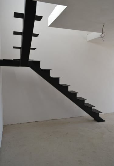 Arton Steel által készített masszív fémlépcső, moduláris gerinccel, korláttal ellátva 