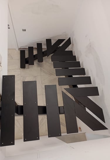 Arton Steel által készített masszív fémlépcső, moduláris gerinccel, korláttal ellátva 