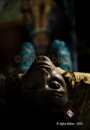 A person wearing blue patterned pants is lying down on a bed, with their legs up in the air and a bl