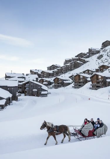 Horse-drawn sleigh ride through the snowy landscape of Avoriaz ski resort, French Alps.