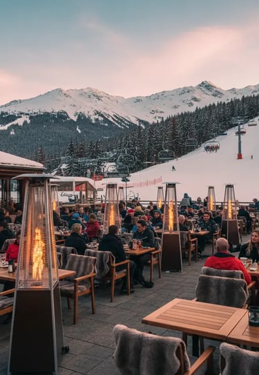 The spacious outdoor terrace of Le Tremplin restaurant in Courchevel, featuring modern fire heaters 