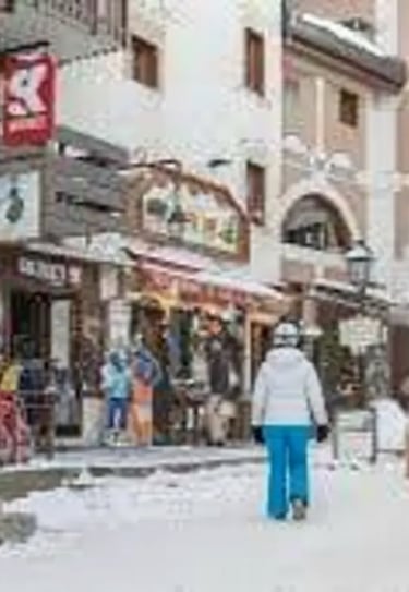 Pedestrians walking through the car-free village center of Avoriaz during winter season.