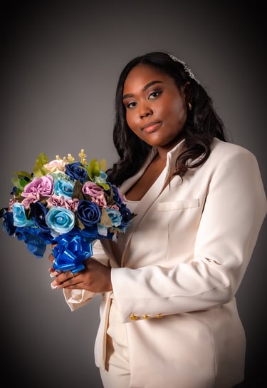 a woman in a white suit and a bouquet of flowers
