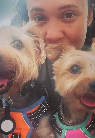 a woman holding two dogs in her arms