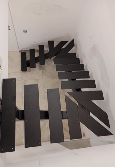 Arton Steel által készített masszív fémlépcső, moduláris gerinccel, korláttal ellátva 