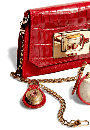 Red crocodile embossed leather handbag with gold chain strap and luxury metallic hardware.