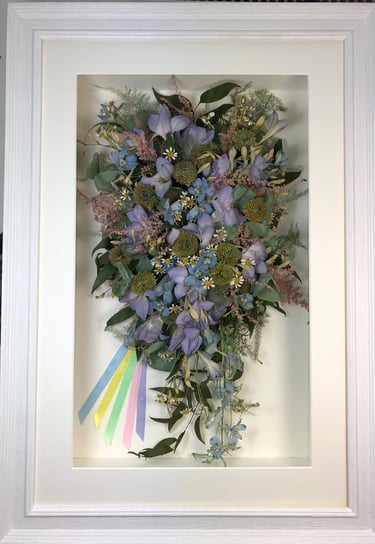 trailing view preserved wedding bouquet with pastel ribbons in a frame
