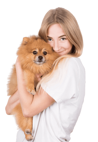 A smiling blonde woman lovingly hugs a fluffy, orange Pomeranian dog.