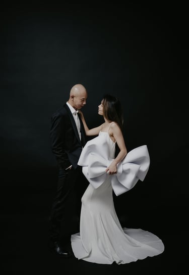 a man and woman in a white dress and tuxedo for pre wedding shoot