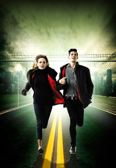 a man and woman running down a road away from a city