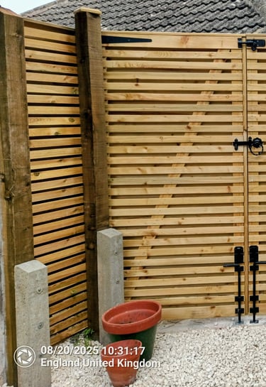 Contemporary horizontal slatted timber garden gates with black hardware installed for backyard security.