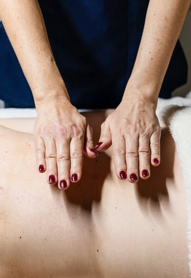 Nathalie Gaullier pose ses mains sur le dos de sa cliente pour faire un massage harmony bien-être