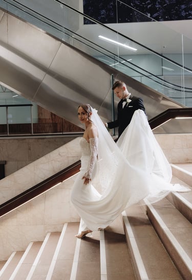 a bride and groom walking down a flight of stairs