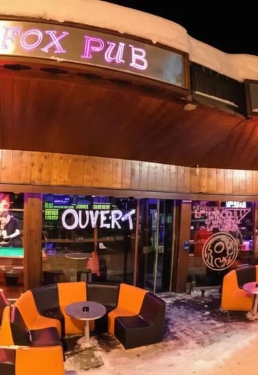 The exterior entrance of Funky Fox Pub in Courchevel at night, featuring neon signs and cozy outdoor