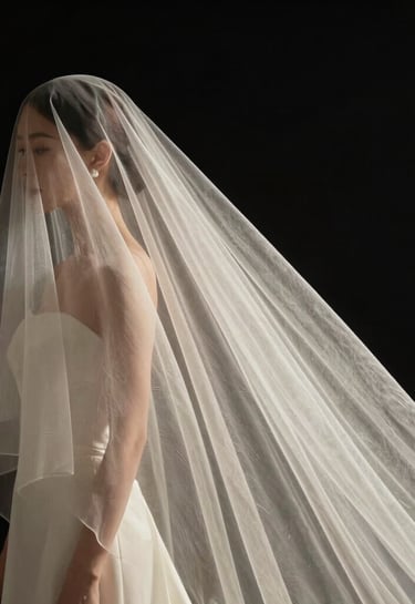 A minimalist composition of a bridal veil blowing in the wind against a midnight black background, soft off-white fabric textures, high-end photography style.