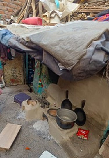 Small Delhi slum home with cooking things outside.