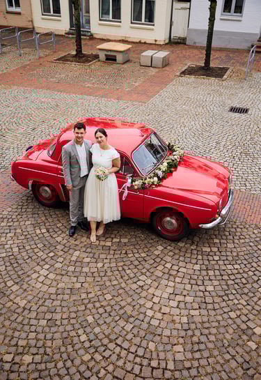 Smiling father giving a toddler in a purple snowsuit a shoulder ride outdoors in winter.