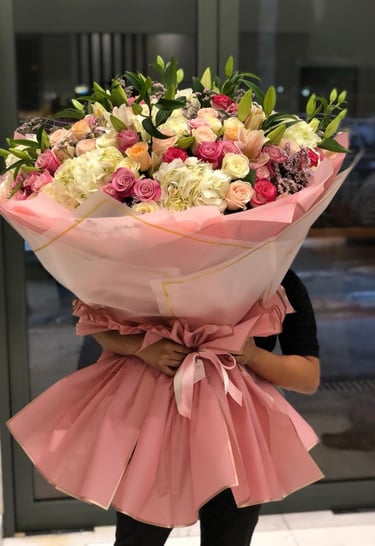 a woman holding a giant bouquet of flowers 