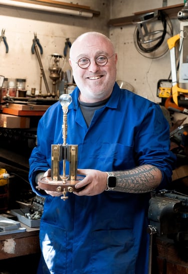 Mains de Yann Franconie, artisan fabricant de luminaires présentant une lampe dans son atelier