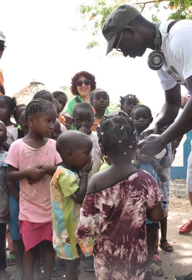Dahomey African Tours Guide leading Tourists and giving gifts to Children in Senegal