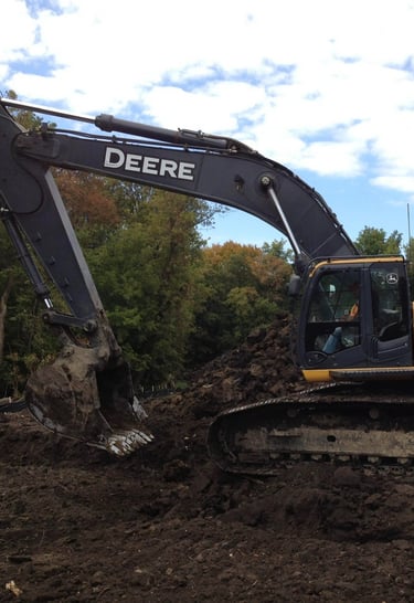 John Deere Excavator digging up dirt