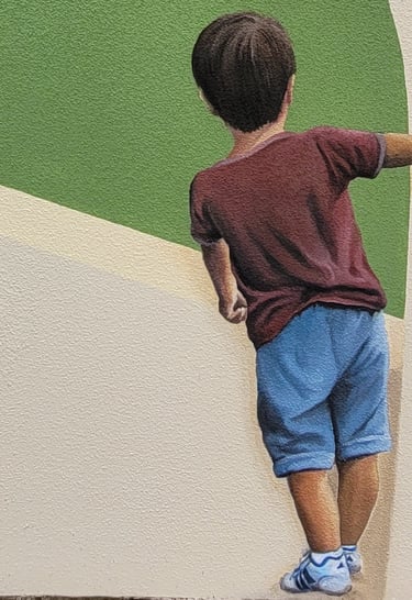 Détail personnage d'une fresque peinte à Viry, Jura : un garçon de dos, tient les pages d'un livre.