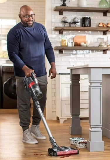 Man with a vacuum cleaning up pet food in a photoshoot