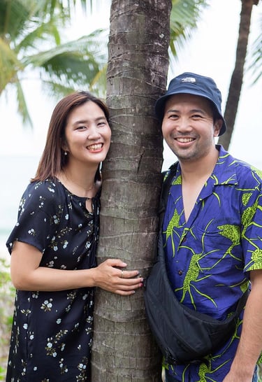 Couple smiling beside palm tree near Khem Beach