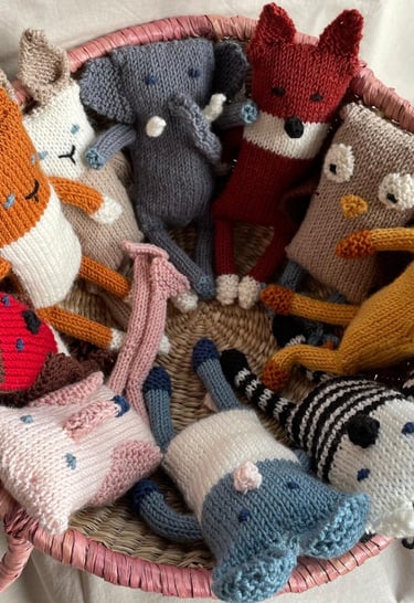 A basket of hand knitted soft toys
