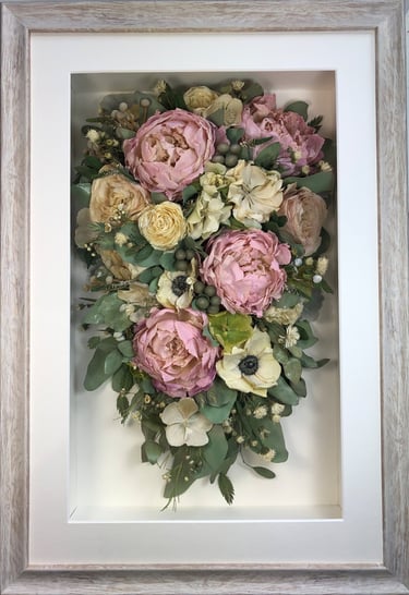 a trailing view preserved wedding bouquet with gorgeous peonies in a frame